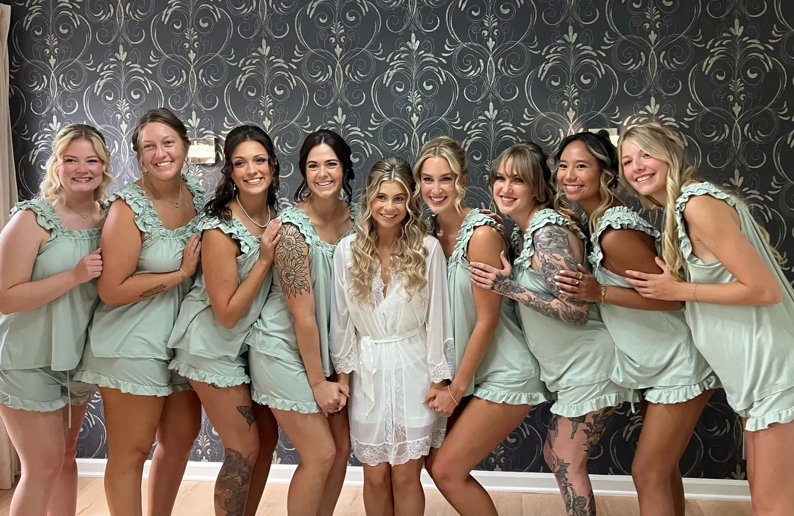 Bride and bridesmaids in matching sage green getting-ready outfits