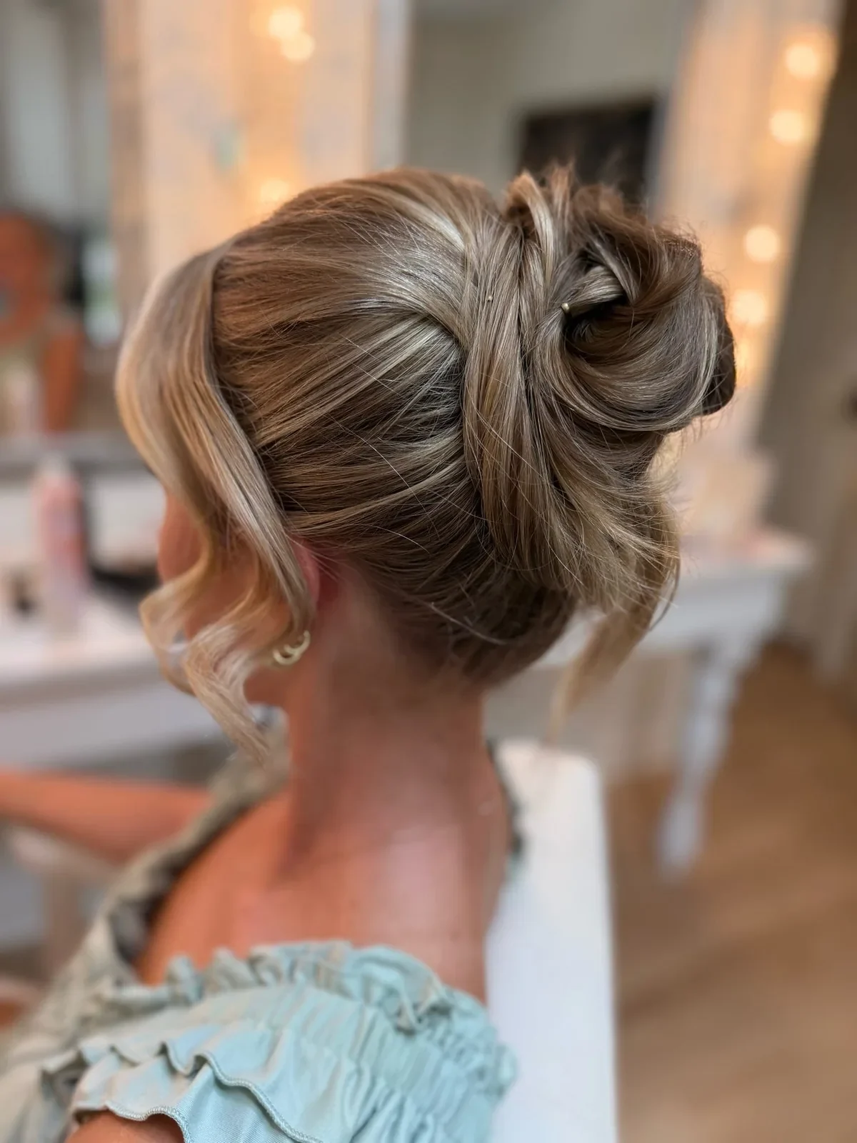 Blonde bridesmaid with a sculpted formal updo