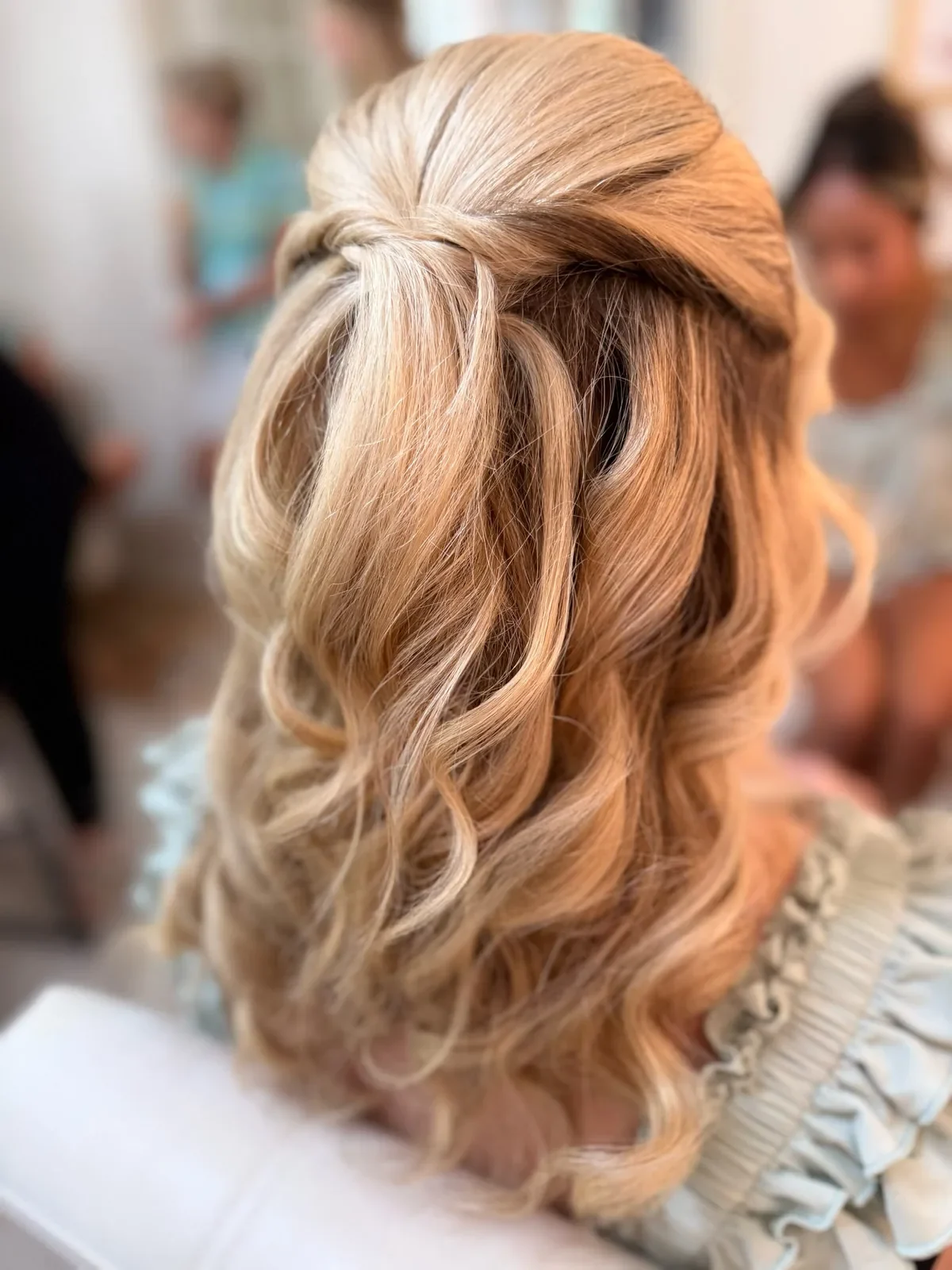 Blonde bridesmaid with twisted half-up hair and soft curls