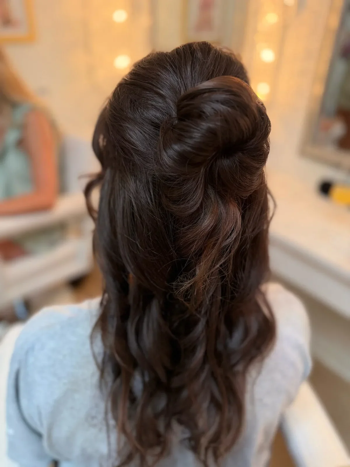 Brunette bridesmaid with a bow in her half-up wavy hairstyle