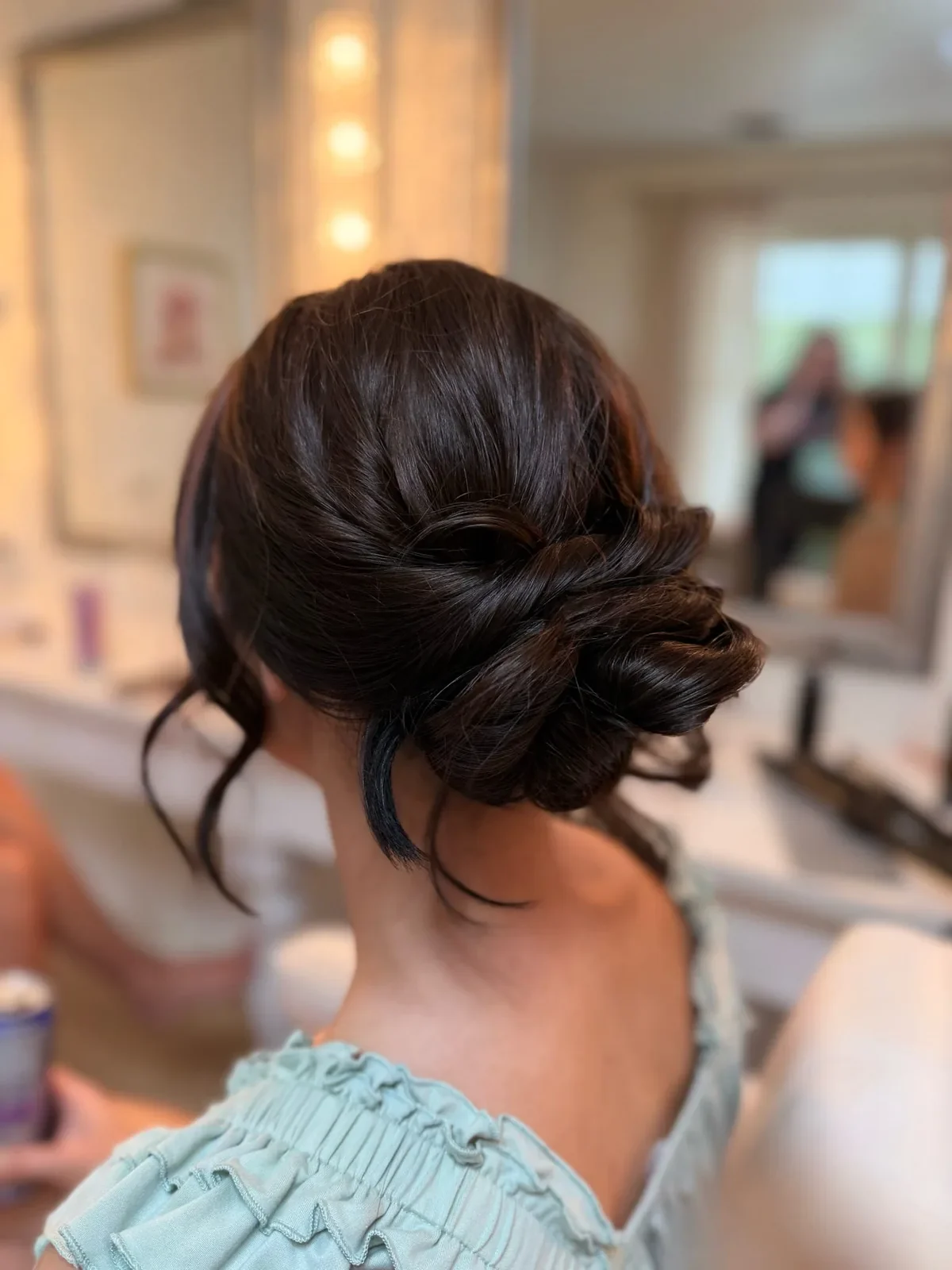Brunette bridesmaid with a polished low bun updo