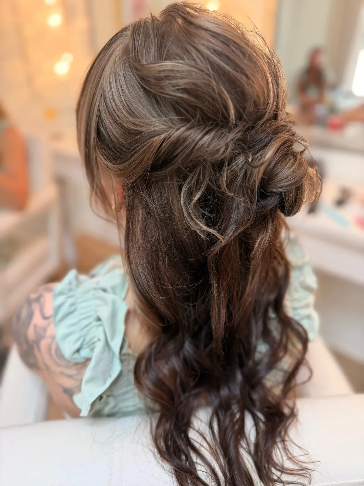Brunette bridesmaid with twisted half-up hair and long waves