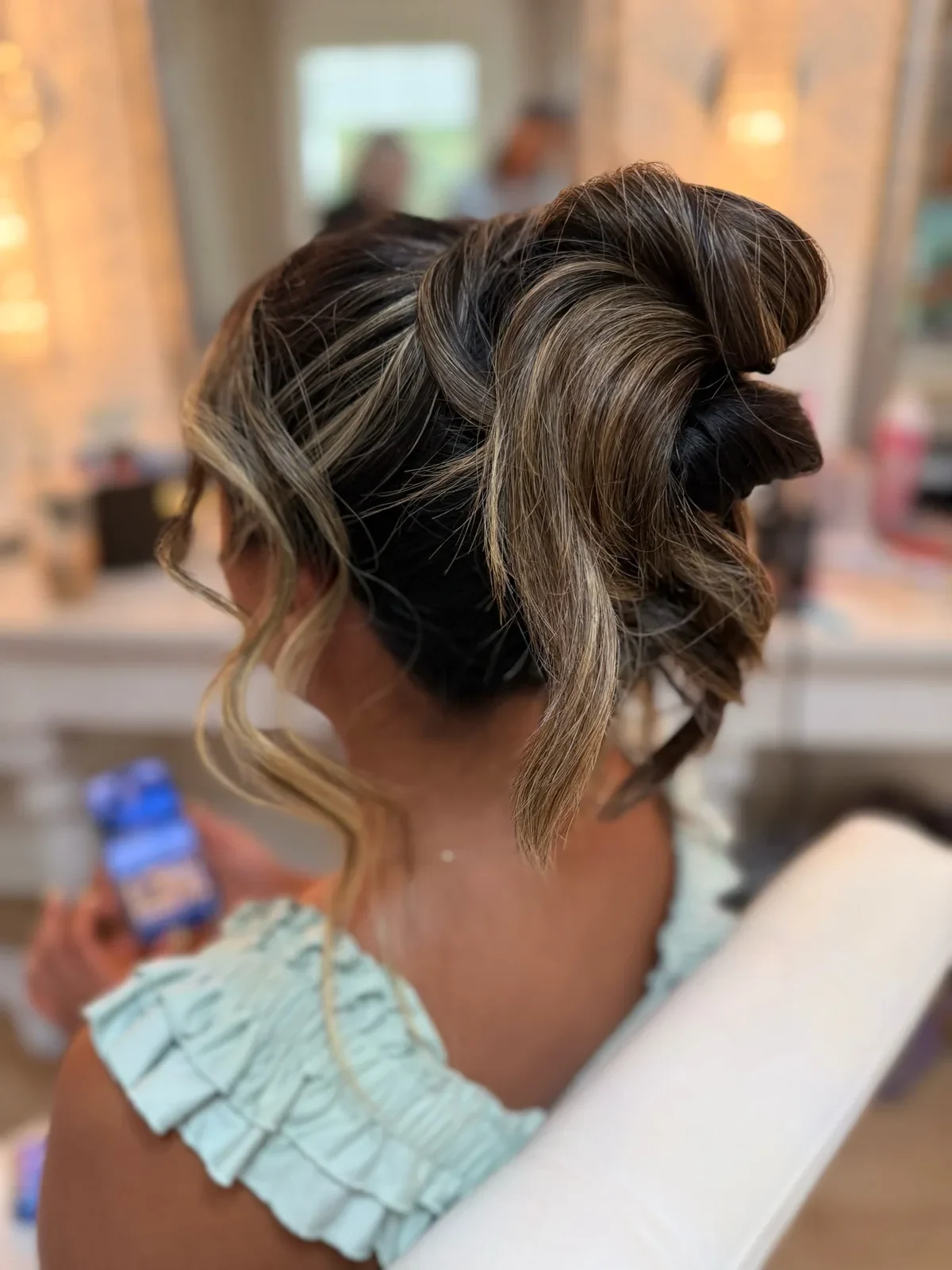Bridesmaid with highlighted hair styled in a sculpted updo