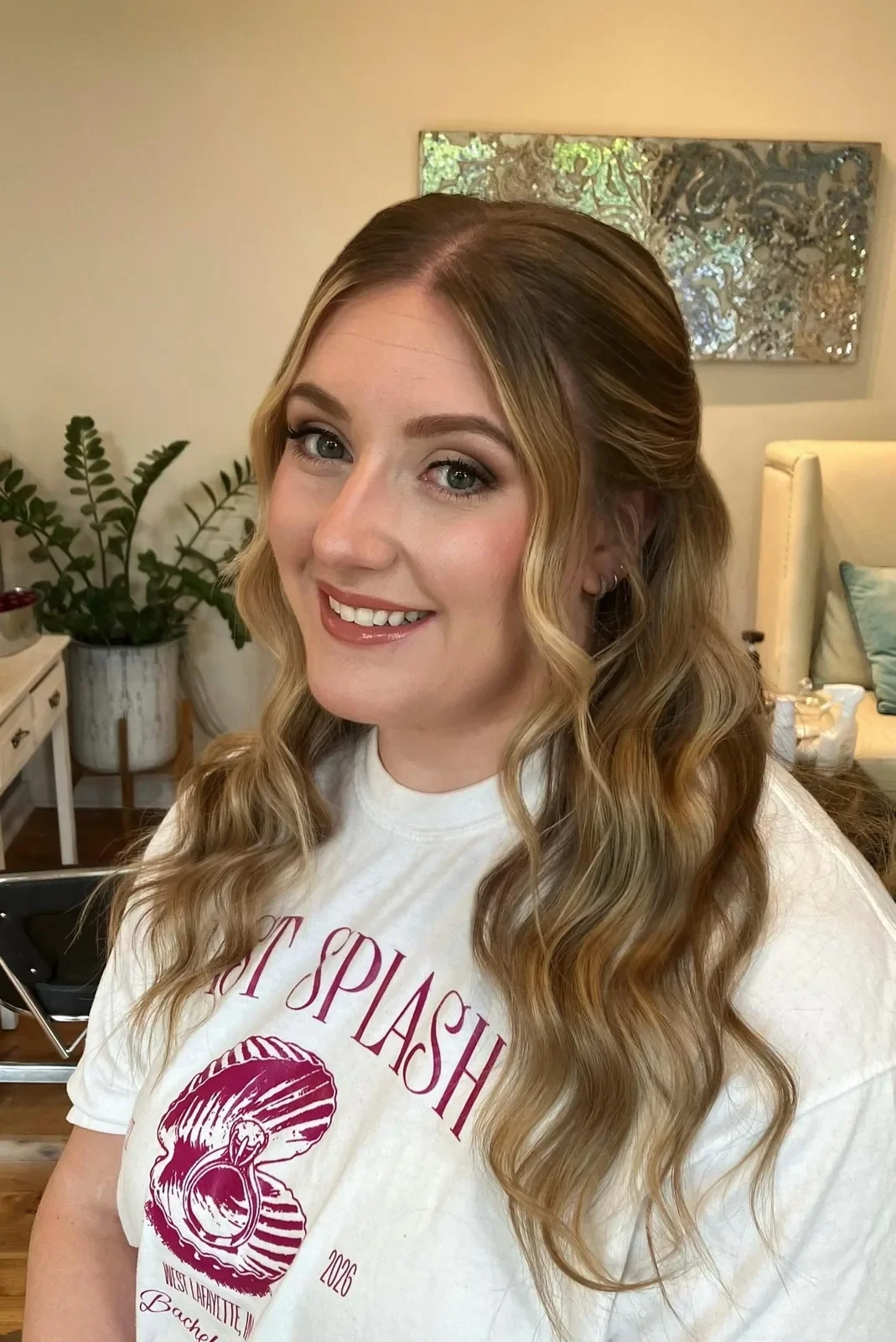 Blonde half-up hairstyle with flowing waves and soft-glam makeup