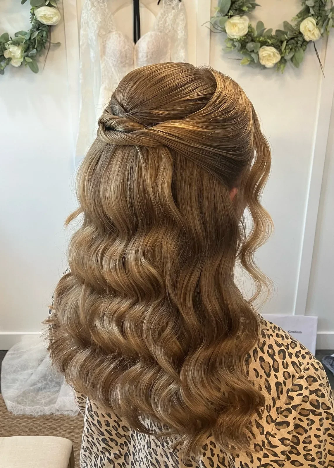 Back view of blonde bridal hair with a twisted half-up detail and Hollywood waves