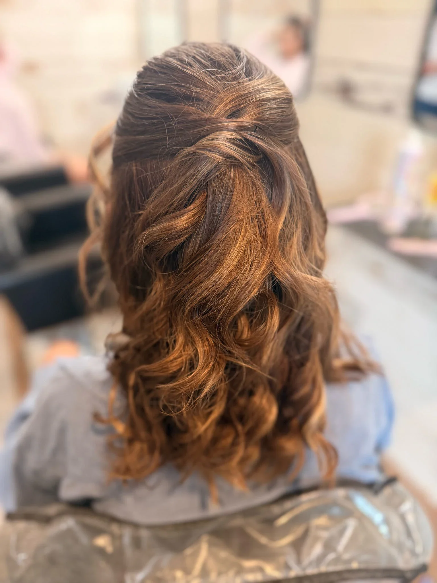 Back view of auburn half-up hair with softly curled lengths