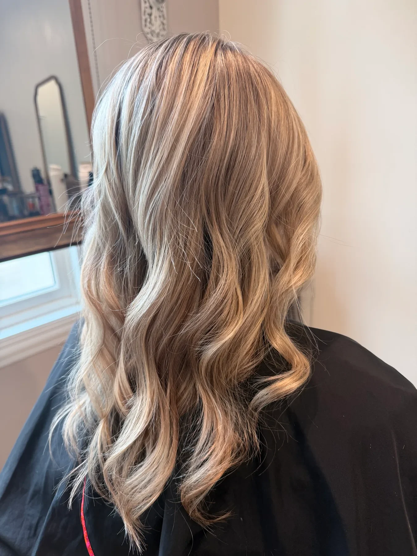 Dimensional blonde balayage with long waves by Glow Salon & Spa in Carmel, Indiana