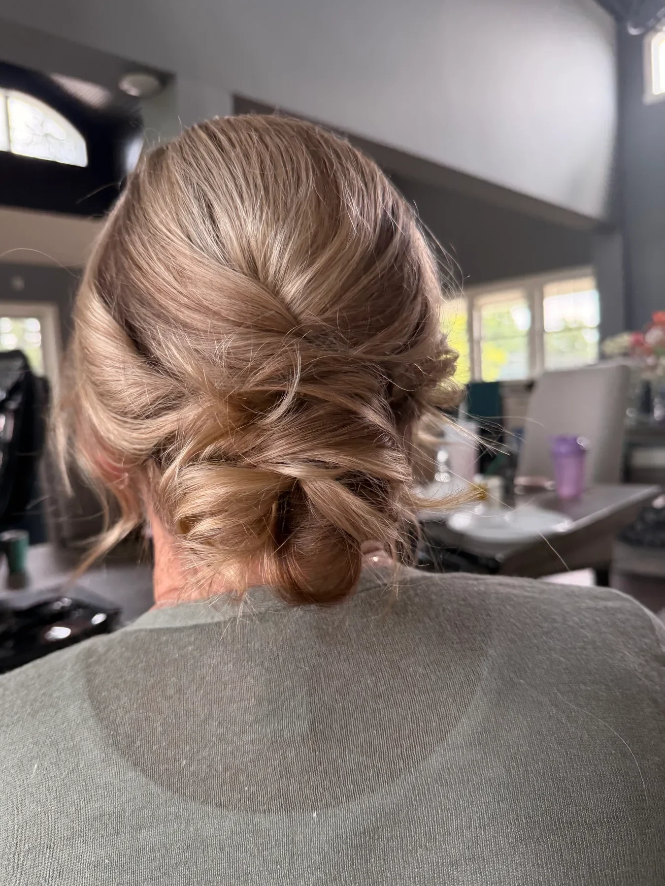 Soft blonde low bun styled for a wedding by Glow Salon & Spa