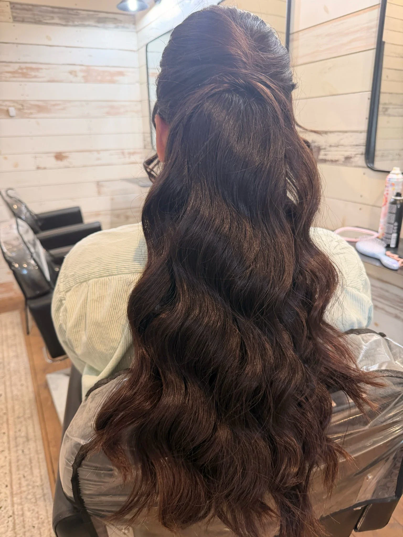 Back view of long brunette half-up hair with smooth, polished waves