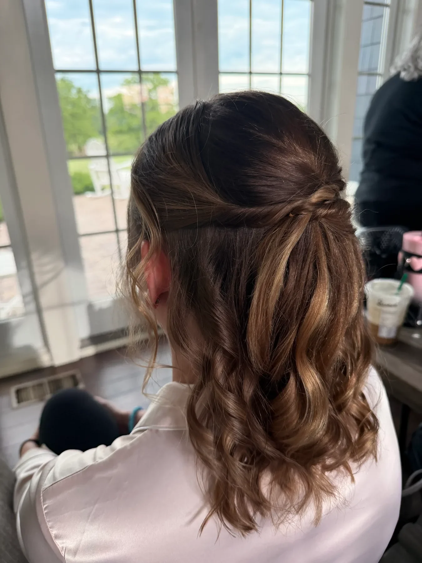 Brunette low wedding bun with braided detail and soft curls