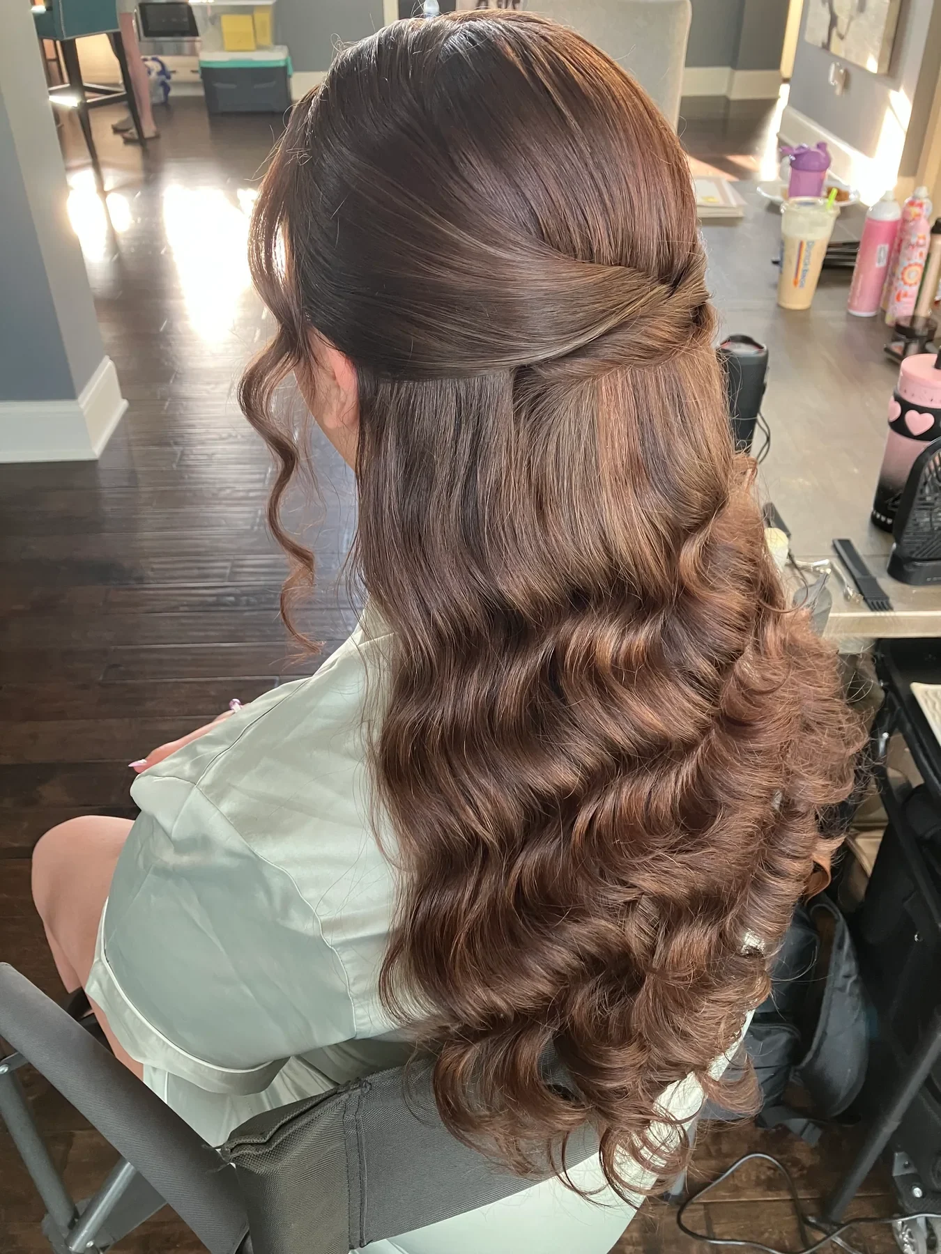 Sleek brunette bridal ponytail with voluminous curls by Glow Salon & Spa