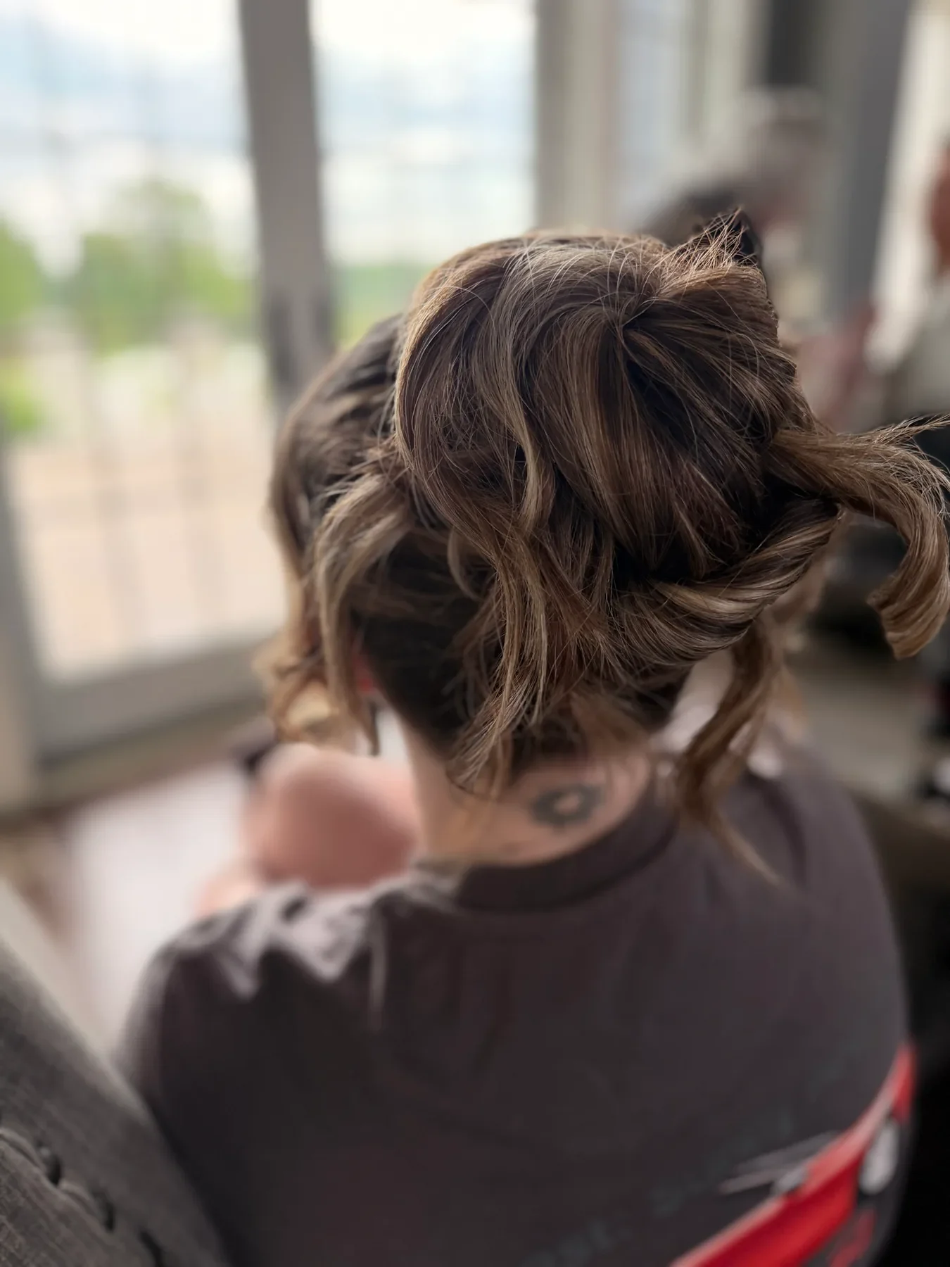 Voluminous brunette updo with loose curls for a formal event