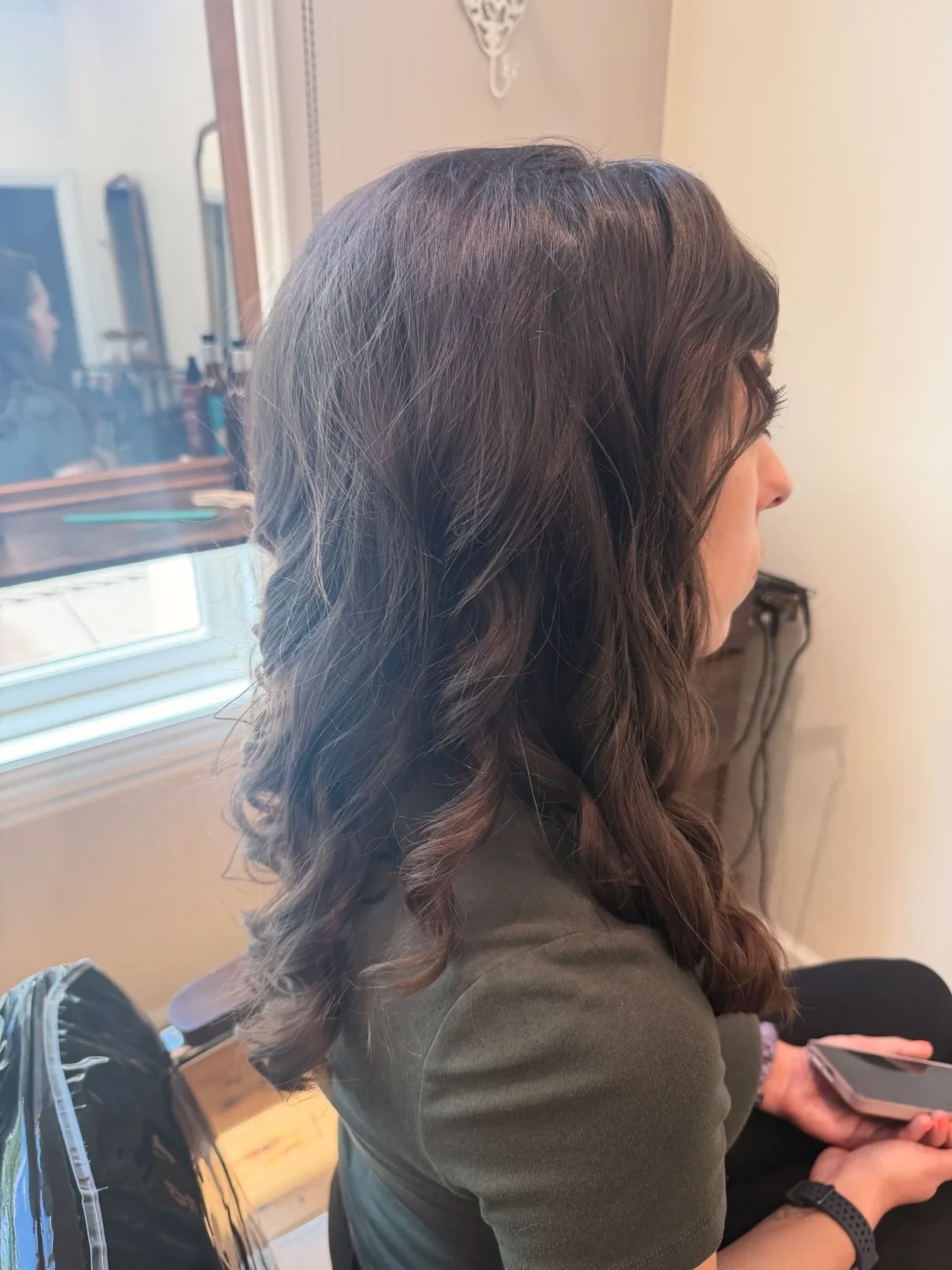 Long dark brunette layers styled in soft waves at Glow Salon & Spa