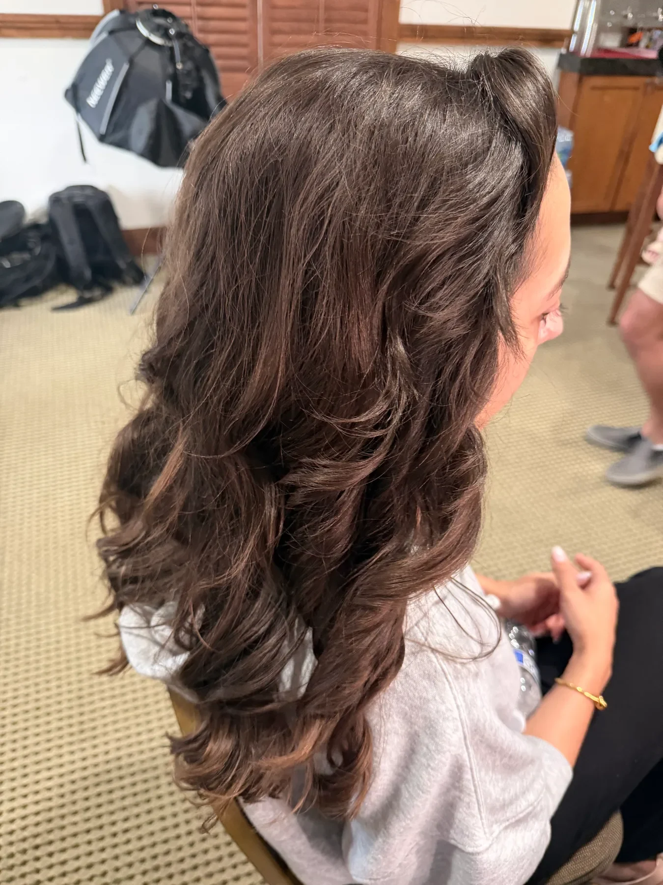 Glossy dark brunette hair with long polished waves by a Carmel hairstylist